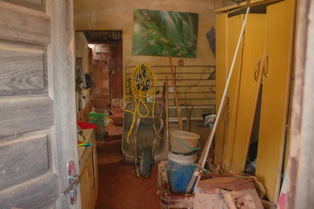 Parte interna da casa de Maria Tereza com objetos destruídos pela chuva e pelo barro