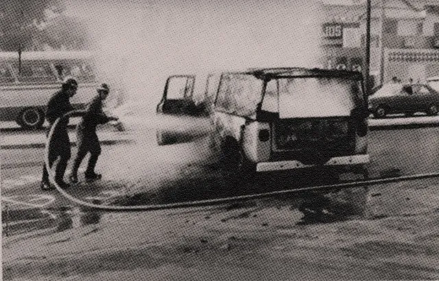 Na imagem o carro da Folha que participou das ações de repressão em chamas com bombeiros tentando apagar o fogo com uma mangueira com água
