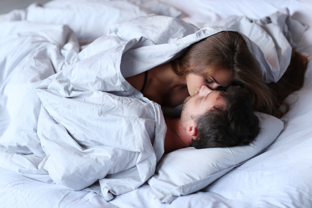 young passionate couple kissing bed